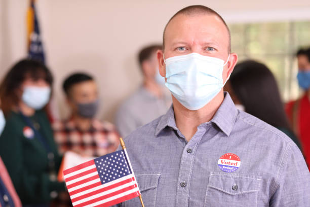 istock Man votes in USA election wearing mask. 1268513850