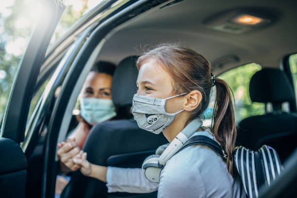 istock Girl with protective mask peeking through the car window 1268514769