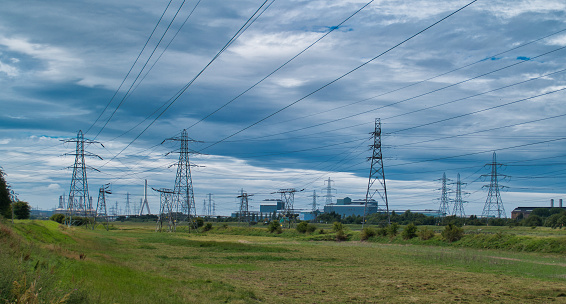 Tall steel pylons at Deeside in Wales UK carry high tension / high voltage power supply lines as part of the UK national grid