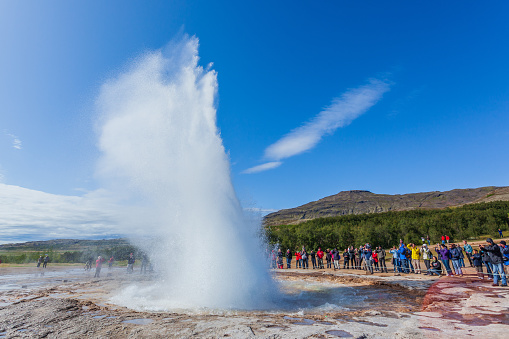 Haukadalsvegur, Iceland - August 6, 2018: People watching the eruption of Strokkur geyser, whilst touring the Golden Circle.