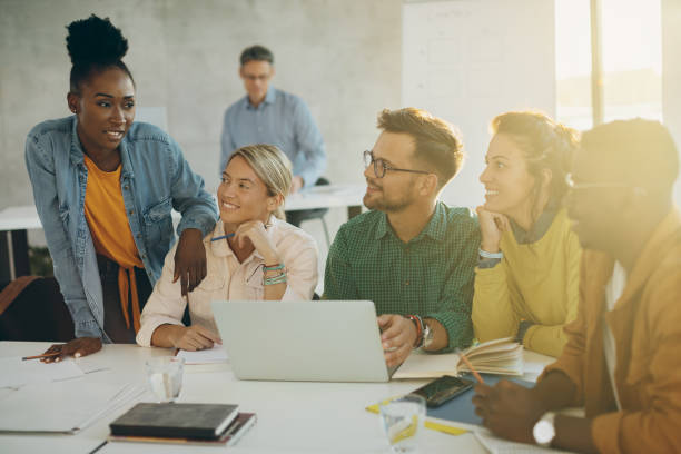 istock Group of college students talking while using laptop and preparing together for an exam. 1268518198