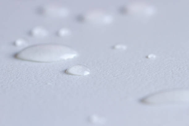 istock Drops of water on a white rough surface. 1268519011