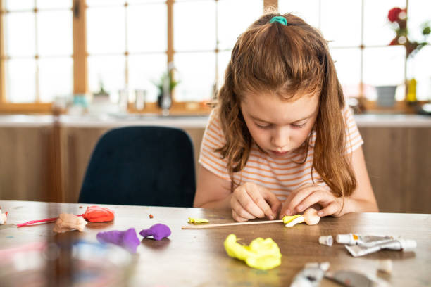 istock Girl playing with child's play clay while sitting at table at home 1268525160