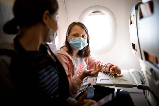 istock Kids with face protective mask talking in airplane 1268533826