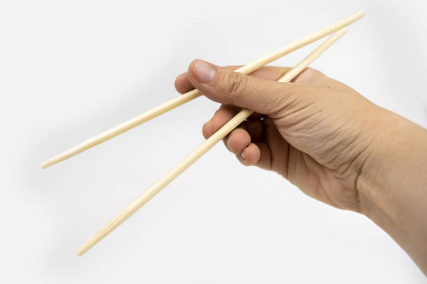 istock Woman using chopsticks, bamboo chopsticks for asian food 1268534078