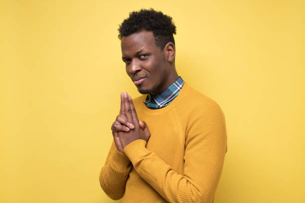 istock African man holding hand on chin and looking at camera generating idea. 1268536670