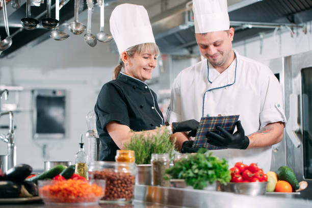 dos chefs discuten el menú en la cocina de un restaurante u hotel. - healthy eating red colors healthcare and medicine fotografías e imágenes de stock