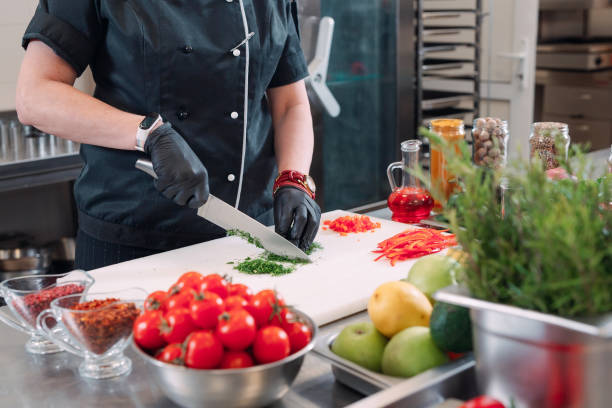 istock A Woman Chef cuts vegetables in the kitchen in a restaurant. 1268538601