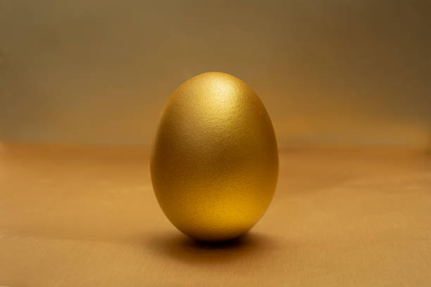 istock A Gold egg on at golden the background 1268539710