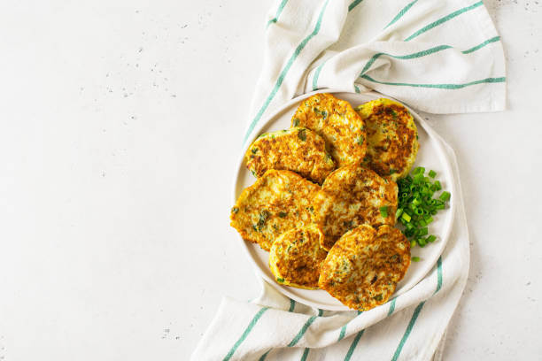 istock Zucchini pancake with onion and parsley on white background 1268540699