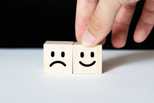 istock Close up customer hand choose smiley face and blurred sad face icon on wood cube, Service rating, satisfaction concept. 1268540731