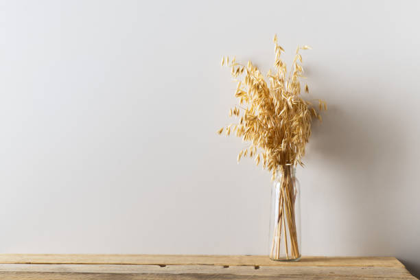 istock Mock up with whte empty wall and dried flowers, oat on wooden table 1268540771