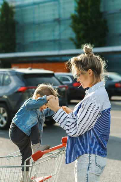 junge mutter und ihr niedlicher kleiner sohn haben spaß mit shoppin - baby beautiful little boys carrying stock-fotos und bilder