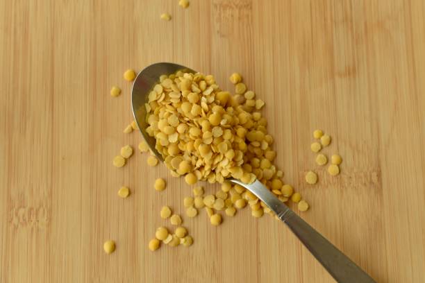 spoon full of uncooked yellow lentils