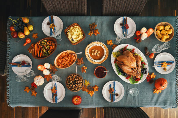 Thanksgiving Party Table Setting Traditional Holiday Stuffed Turkey Dinner Thanksgiving Party Table Setting. Traditional Holiday Dinner with Stuffed Turkey, Roasted Potatoes, Cranberry Sauce, Vegetables and Pumpkin Pie winter food top view stock pictures, royalty-free photos & images
