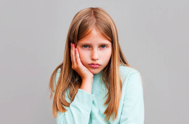 istock Bright girl bored isolated on gray background 1268545581