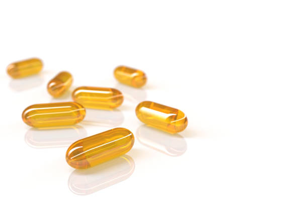 3D render of fish oil capsules on white background with selective focus technique 3D photography cod liver oil fish oil vitamin a pill stock pictures, royalty-free photos & images