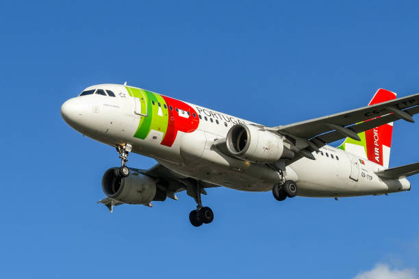 airbus a319 jet operated by portuguese airline tap against a blue sky - tap airplane imagens e fotografias de stock