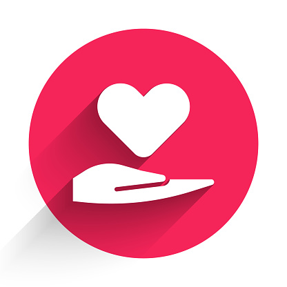 istock White Heart on hand icon isolated with long shadow. Hand giving love symbol. Valentines day symbol. Red circle button. Vector Illustration 1268550307