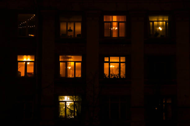 Glowing windows of an apartment building stock photo