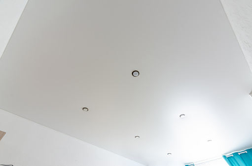 Fragment of the room's interior - white matte stretch ceiling with a series of spotlights