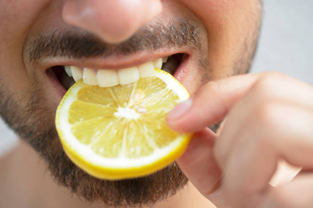 młody człowiek jedzący cytrynę - cynga zdjęcia i obrazy z banku zdjęć