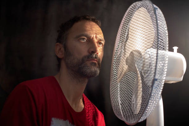 istock middle-aged man fanning himself next to a fan 1268552206