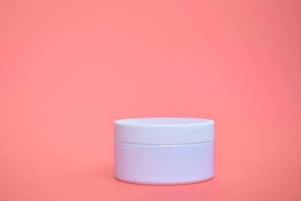 istock Round, white, plastic cosmetic jar, layout isolated on a pink background. 1268553616