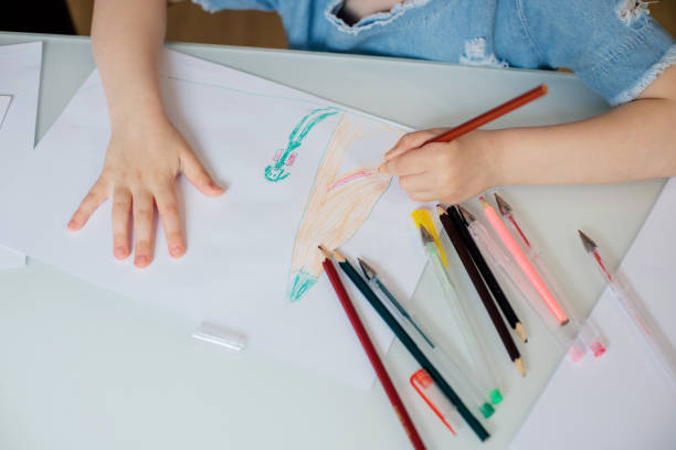 istock Children's pens draw on white paper with colored pencils 1268553706