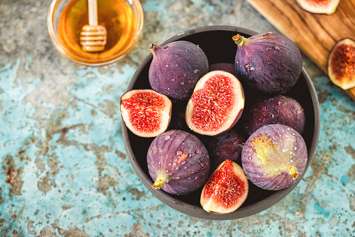 Fresh organic figs and sweet honey on the rustic background