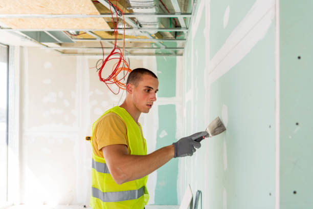 istock Renovation at home. Plasterer spreading plaster on wall. 1268559658