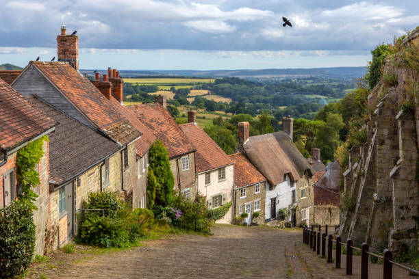 Gold Hill in Shaftesbury in Dorset, UK Looking down the picturesque Gold Hill in the town of Shaftesbury in Dorset, UK.  The hill was made famous by being in the iconic Hovis advert. shaftesbury england stock pictures, royalty-free photos & images