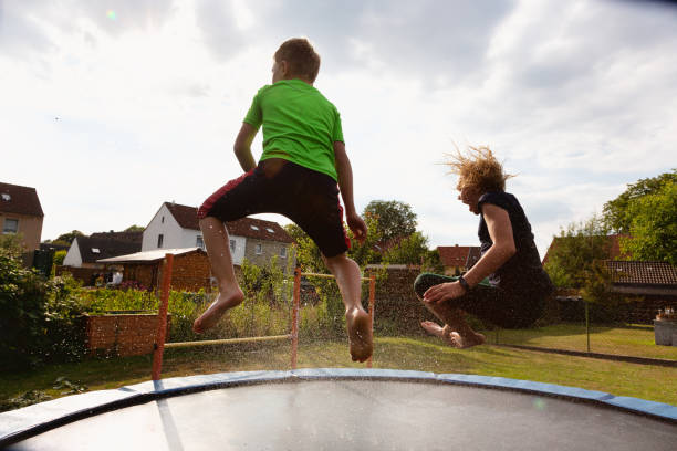 istock Girl and boy having water fun jumping on trampoline 1268561057