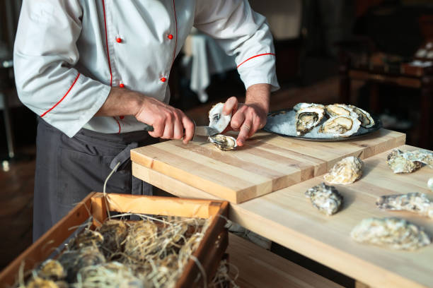 istock Opening the hollow and flat oysters. Chef opens oysters in the restaurant. 1268561191
