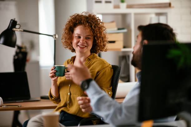 istock Businesswoman and businessman discussing work while drinking coffee. 1268561481