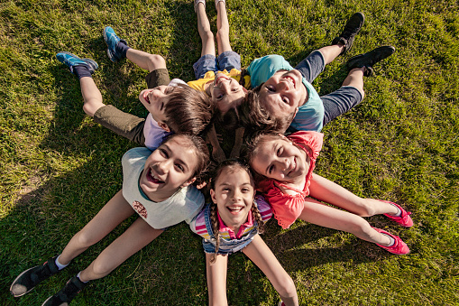 High angle view of a group of kids sitting on the grass