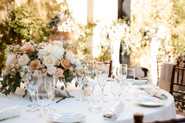 arredamento tavolo da ricevimento all'aperto - tavoli rotondi con tovaglie bianche e pezzi floreali al centro - wedding centerpiece foto e immagini stock