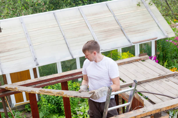 the man knocks an old rotten wooden plank with a hammer - carpenter construction garbage ruined imagens e fotografias de stock