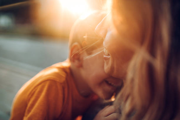 Mother and son playing outdoors, having fun and toothy smile