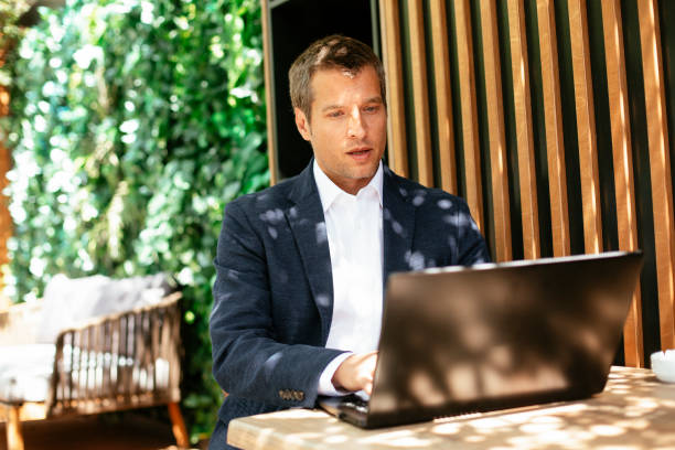 istock Handsome businessman dressed in the suit drinking wine. 1268571054