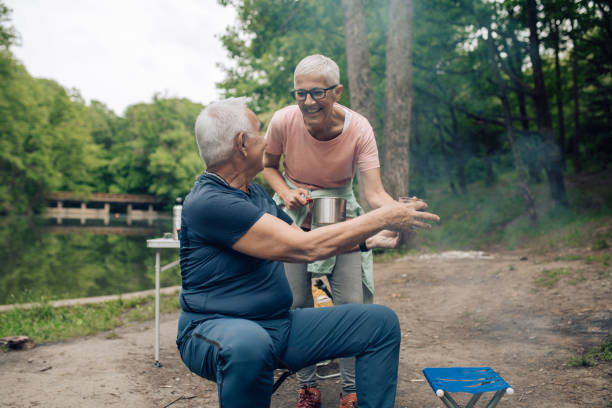 istock Senior couple drinking tea and enjoying camping by the river 1268579999