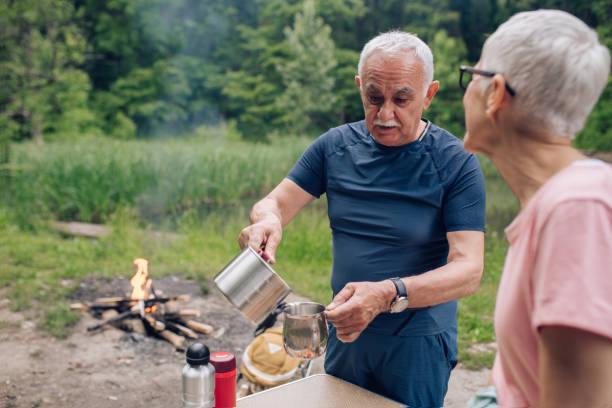 istock Senior man making tea for him and his wife during camping 1268580004