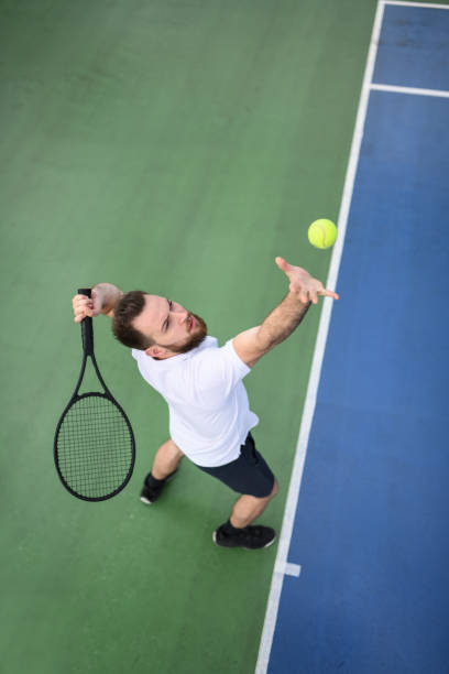istock Handsome Male Tennis Player Serving Ball 1268580167
