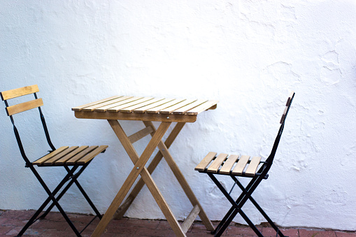 Empty Cafe Table with Two Chairs, White Plaster Wall Background