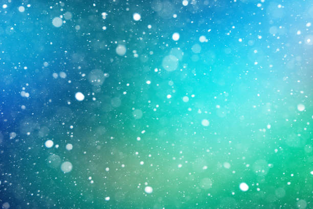 istock Winter White Falling Snow and Ice Over Blurred Defocused Blue and Green Abstract Background for Christmas and New Years Holiday Season 1268583261