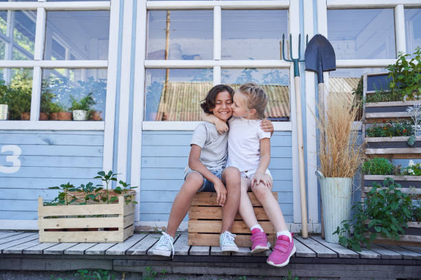 istock Adorable happy siblings hugging outside the house 1268584430