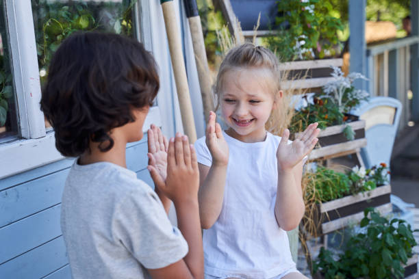 istock Cheerful siblings playing patty-cake game outside the house 1268584438