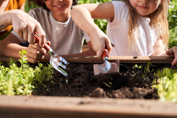 Little girl and boy preparing soil for plants
