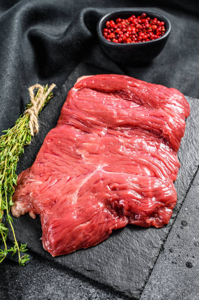 istock Raw outside skirt steak, marbled meat. Black background. Top view 1268586347
