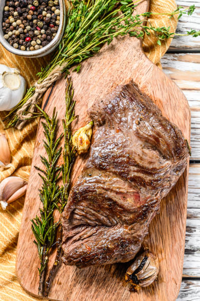 istock Grilled outside skirt steak on a chopping Board. White background. Top view 1268586360